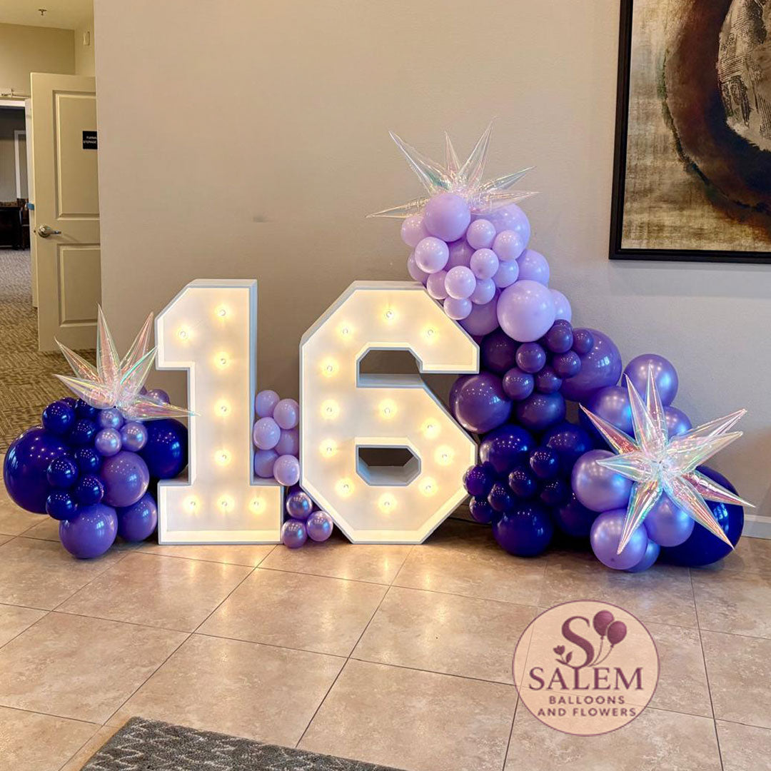Architectural marquee number display featuring warm-white bulbs and professional balloon styling in a deep violet palette, curated by Salem Balloons and Flowers in McMinnville.