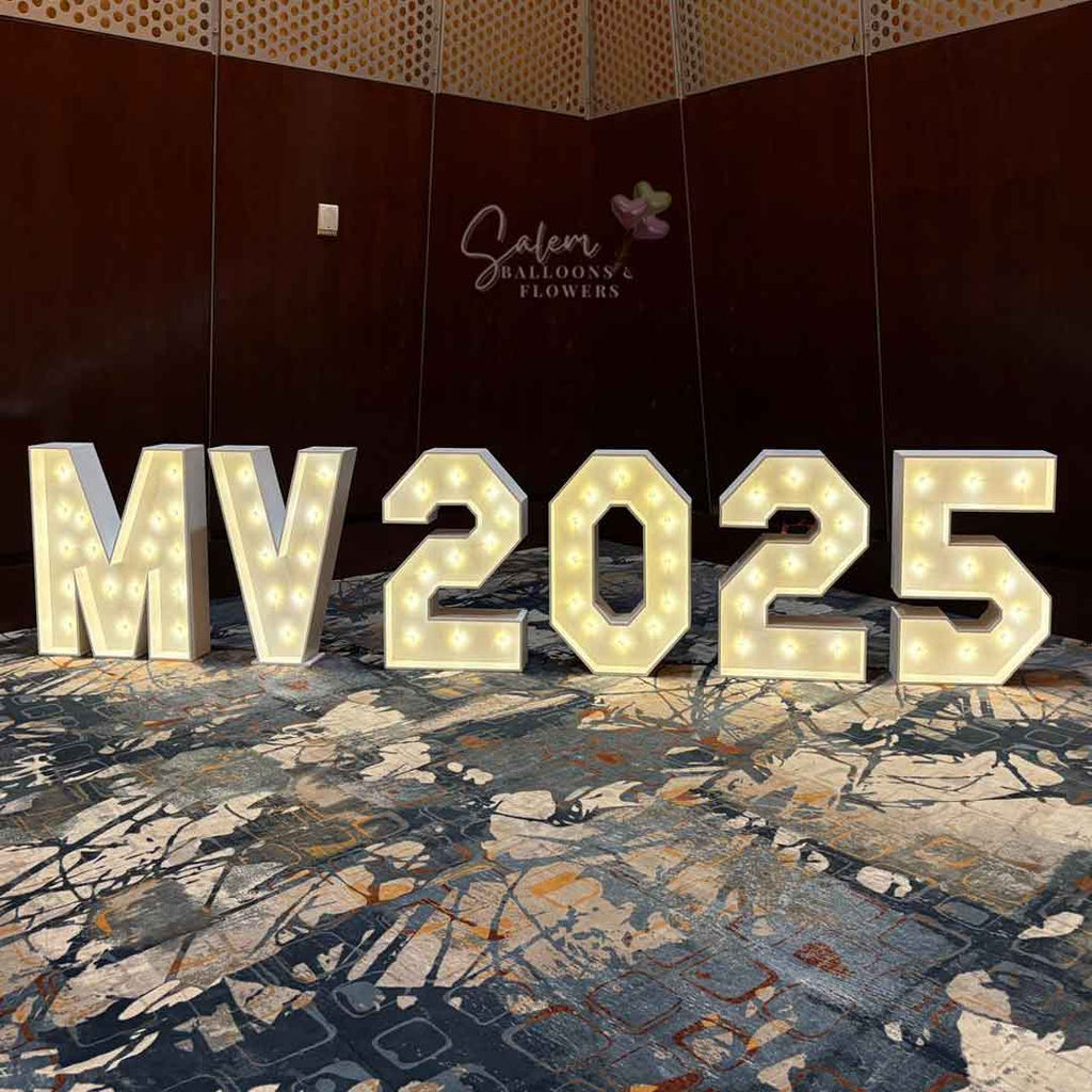 Decorative letters 'MV2025' with lights on a patterned floor, brand 'Salem Balloons & Flowers' visible. Oregon party rental.