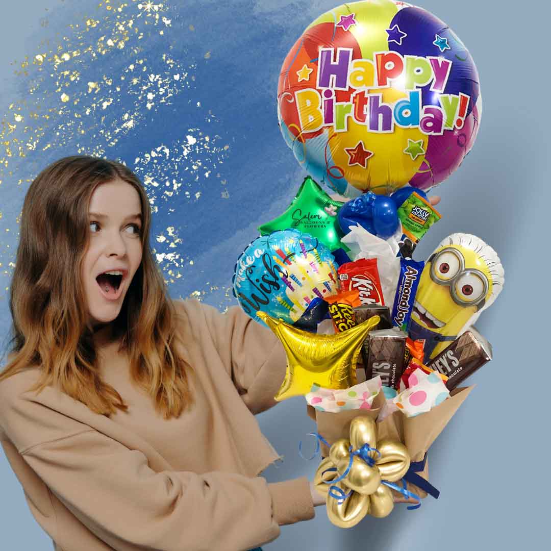 A girl holding a Minion-themed candy-balloon box. With a Mini Minion Mylar balloon holding a "Happy Birthday" balloon, in a box filled with candy, chocolates and balloons. Balloon delivery in Salem Oregon and nearby cities.
