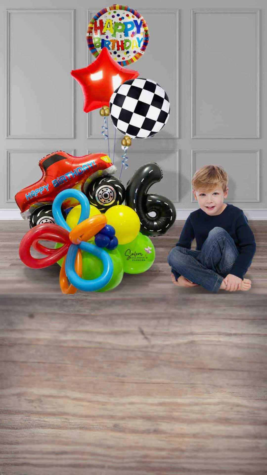 Boy sitting next to a colorful Monster truck themed balloon bouquet with number 6. Salem Oregon Balloon delivery and balloon decor