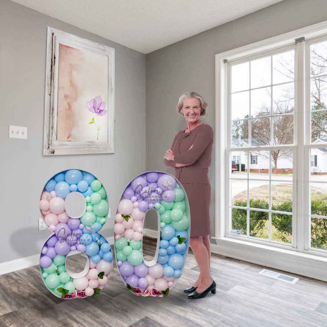 An old lady standing next to a 3 ft tall Mosaic Balloon number 80 in pastel colors embellished with pink roses. Balloon Decor Oregon. Balloon Delivery.