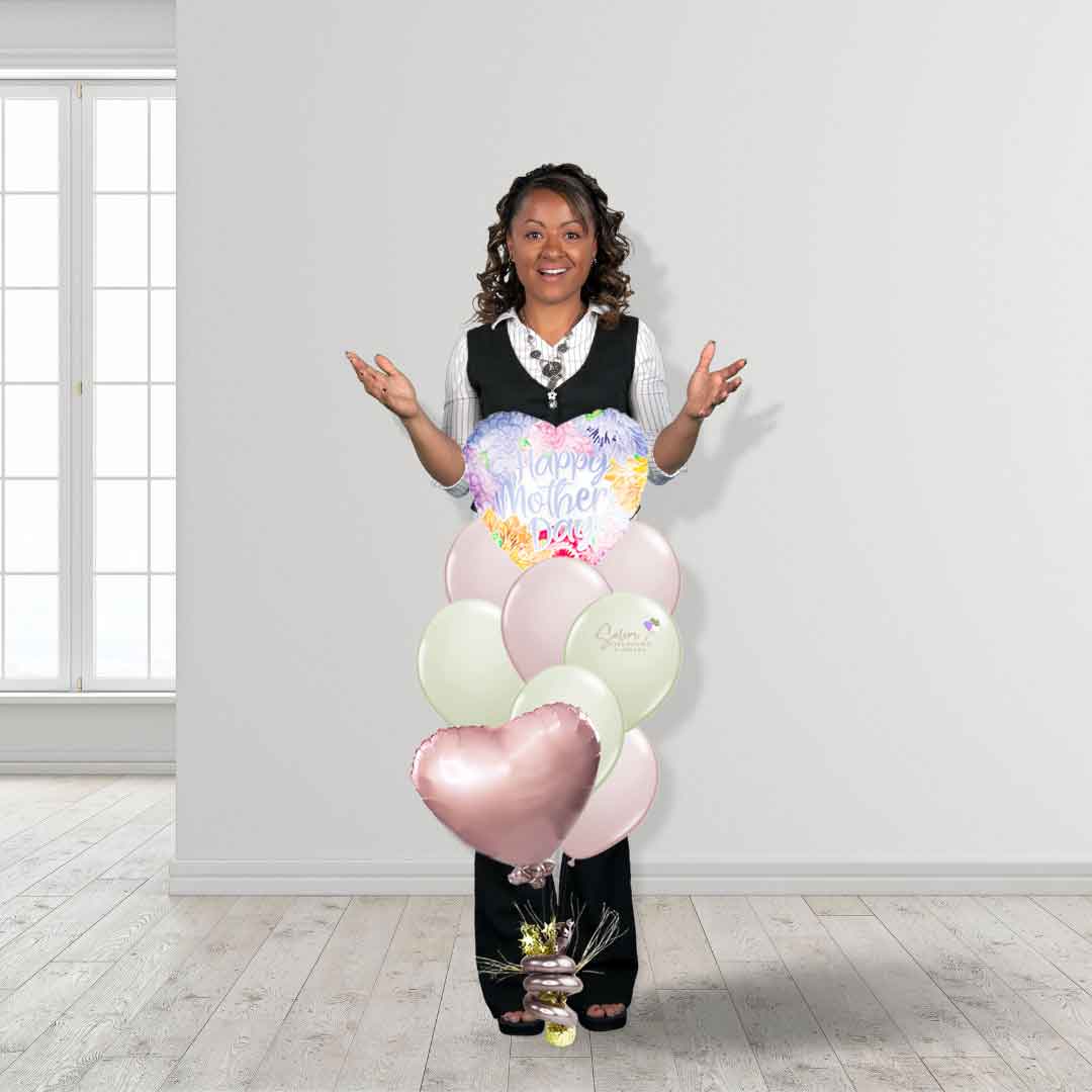A mom standing behind a Mother's Day balloon bouquet with a 