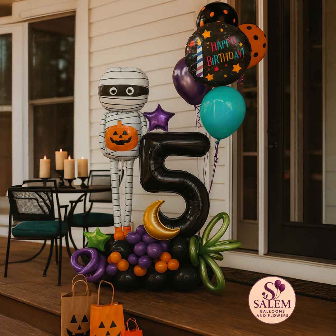 Halloween-themed balloon arrangement with number '5' and a tall mummy balloon with decorations on a porch. Oregon balloon delivery.