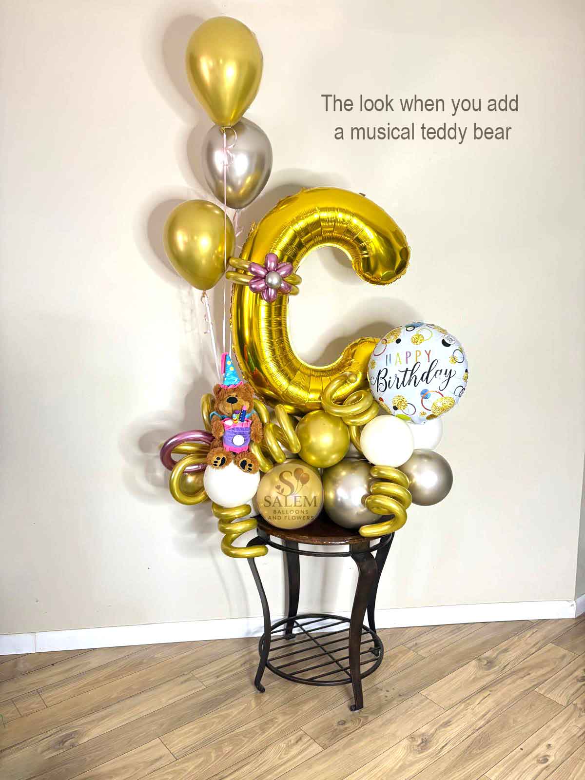 balloon bouquet featuring a large letter balloon decorated with helium balloons in gold and silver standing on a table in front of a wall. Oregon balloon delivery