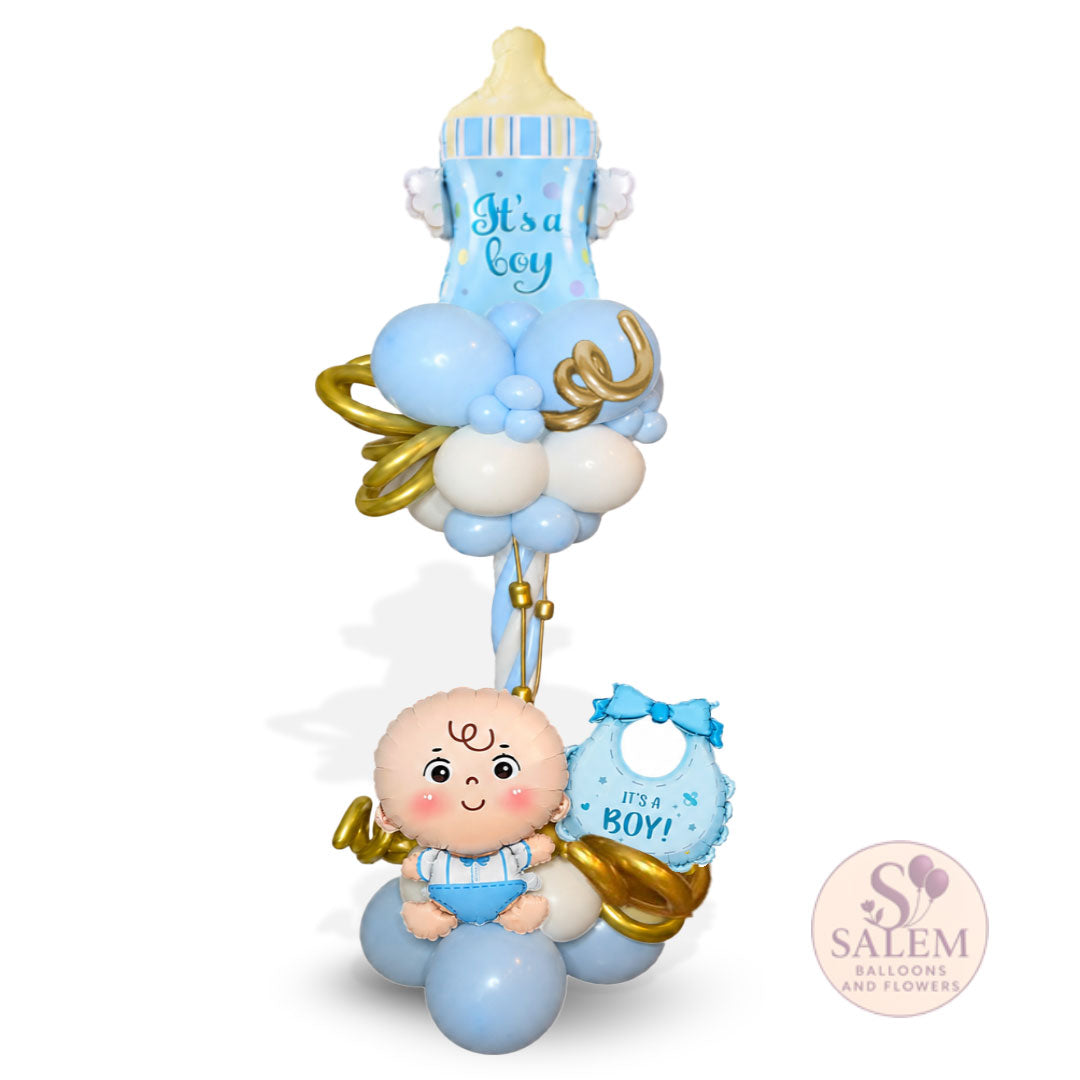 A baby shower balloon bouquet featuring a baby bottle balloon with 'It's a boy' text, a baby figure balloon, a bib balloon, and light blue and white balloons with gold ribbon accents, shown on a white background with a Salem Balloons and Flowers logo.