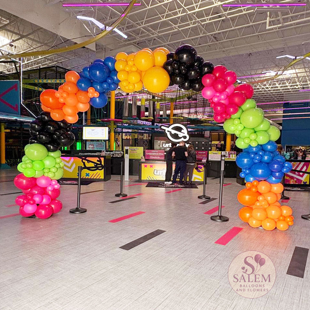 14W x 10H ft Organic balloon arch decorating the grand entry in vibrant colors for the grand Opening of Urban Air in Salem Oregon.