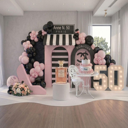 Decorative Parisian themed balloon decor setup with balloon garlands, a cake on a bistro paris style table, and '50' lights in a venue room. Balloon decor. Oregon.