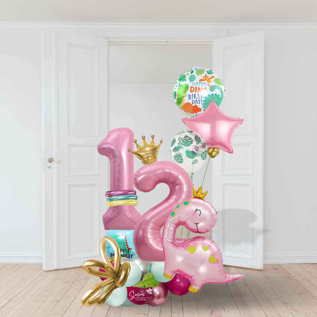 A white room with open doors with a Pink dinosaur themed number balloon marquee. Featuring a large pink dinosaur wearing a golden crown, decorated with helium balloons. Balloons salem oregon. Balloon delivery