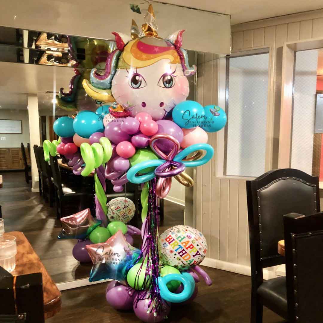 Unicorn themed Balloon Column. In vibrant pastel colors. Featuring a large Unicorn head as topper. Picture taken in "La Margarita" restaurant in Downtown Salem.  Oregon Balloon Decor