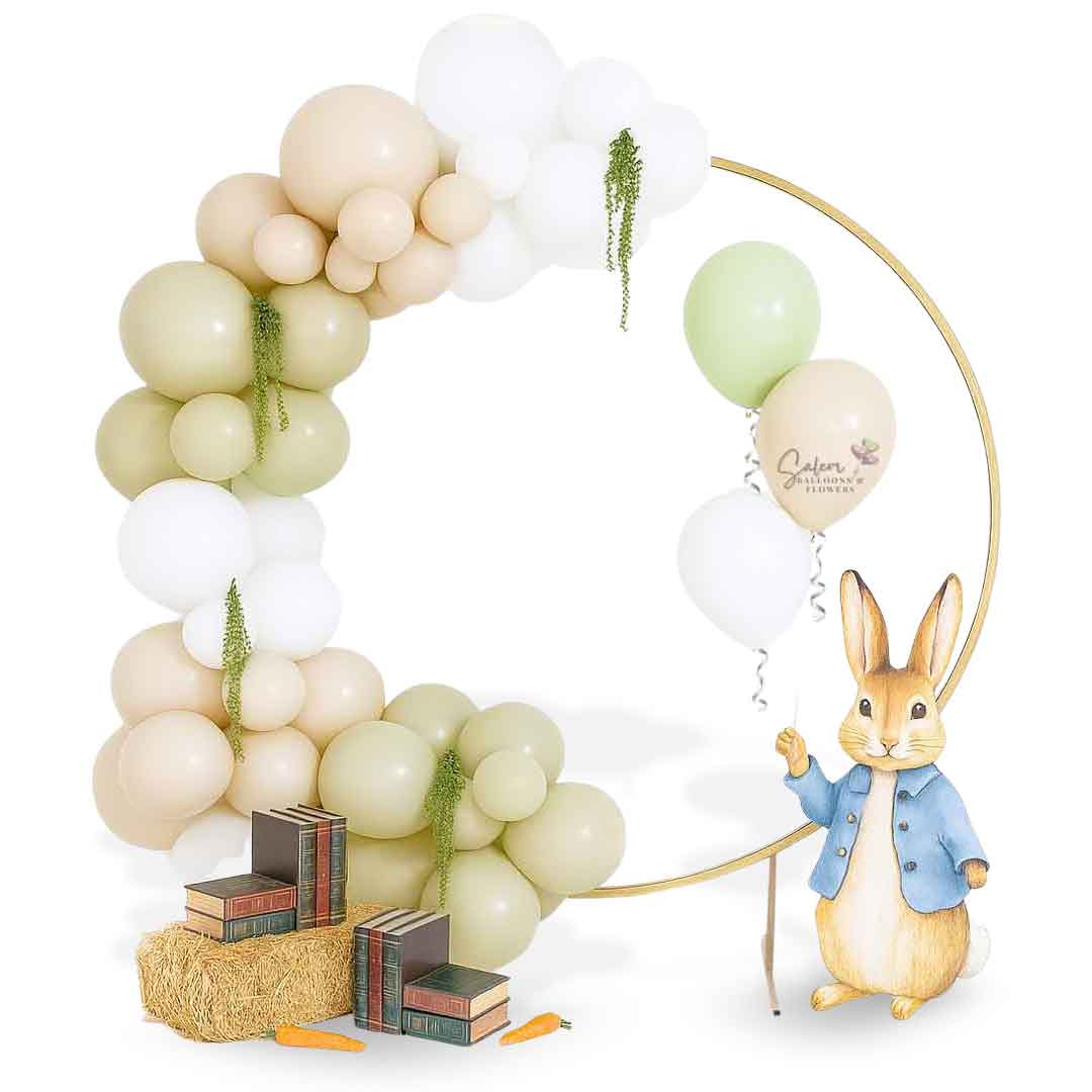 A Peter Rabbit inspired balloon hoop in sage green, beige, and white with books and a rabbit cutout holding balloons. Balloon decor Oregon.