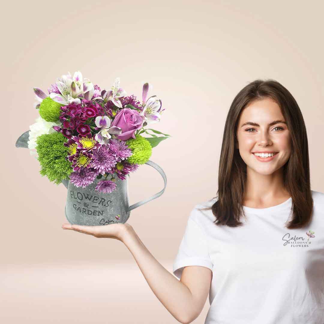 a girl holding a fresh flower arrangement in a decorative Flower can. Salem Oregon flower delivery