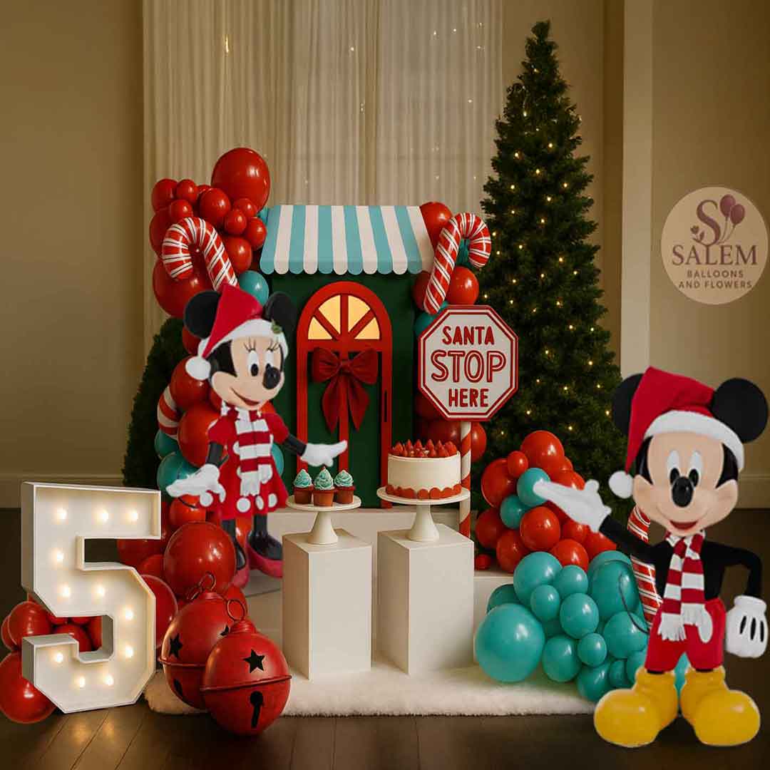 Balloon Christmas decor for a birthday with a tall Mickey and Minnie figurines, Christmas trees, cake stands, jingle bells, a tall Marquee number 5. Balloon decor Oregon.