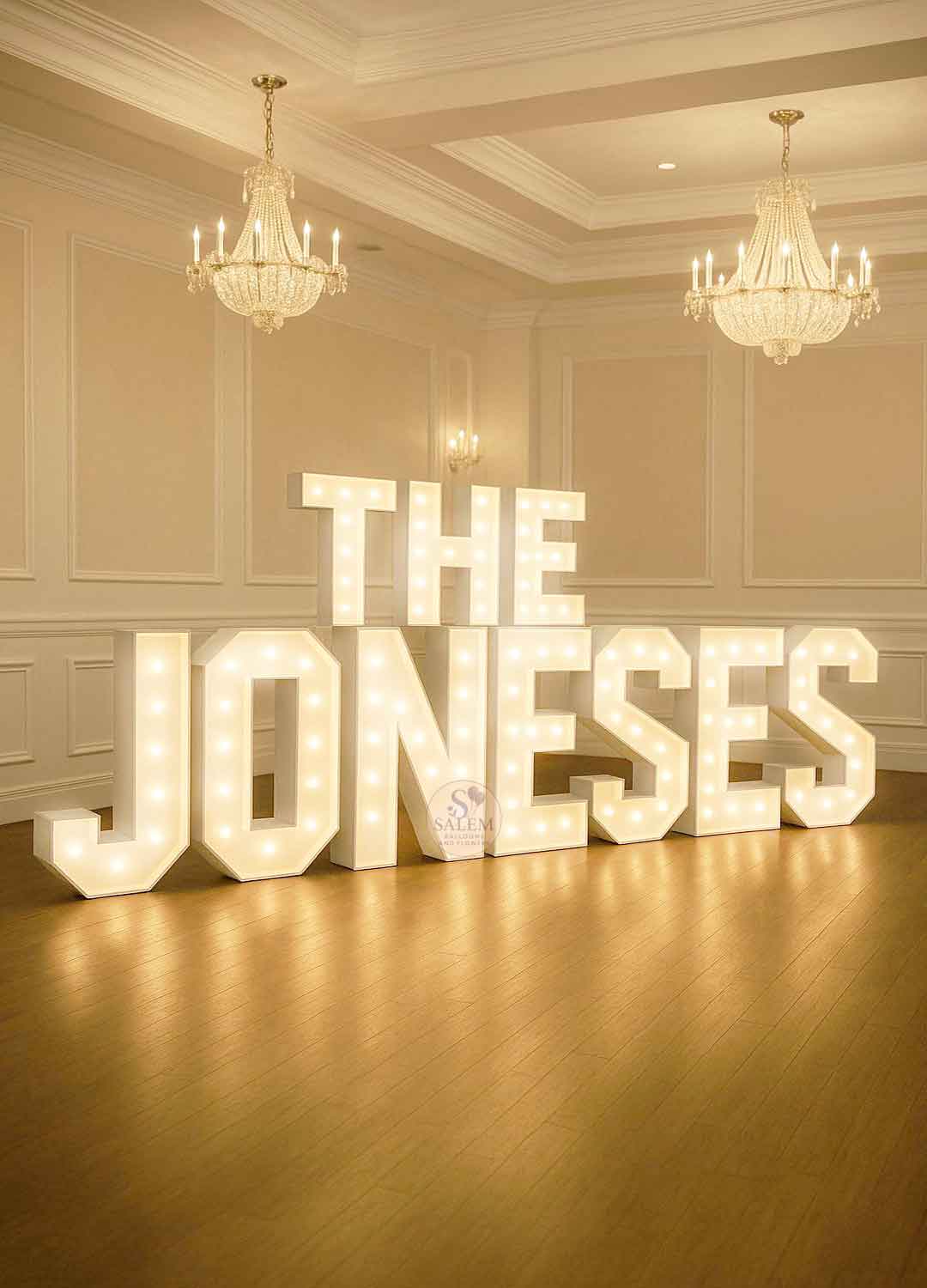 White Marquee Letter display spelling The Joneses in a venue, set in a  white room with crown molding and chandeliers.  Wedding decor. Oregon.