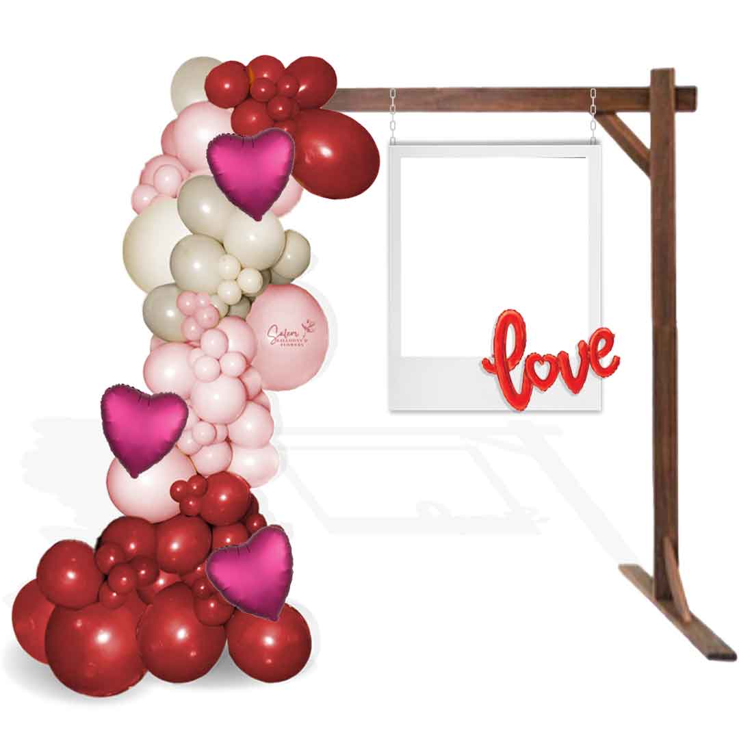Valentine's Day Balloon Decoration. Decorated with a charming balloon garland on a rustic wood frame and complete with a cute polaroid frame prop, with a LOVE sign balloon. Salem Oregon. Balloon decorations.