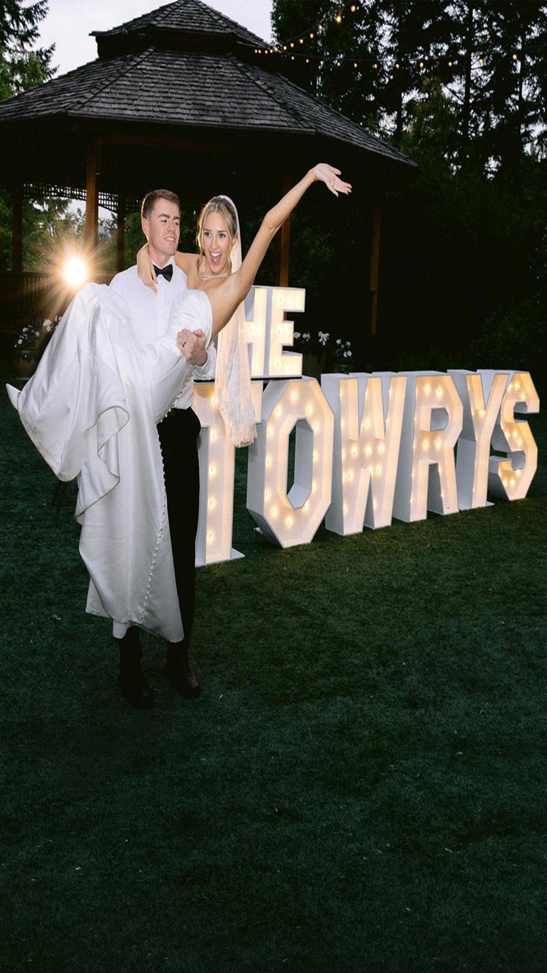 Bride and groom posing in front of illuminated “THE TOWRYS” marquee letters during an outdoor wedding reception at Paradise Springs in Monroe, Oregon. Luxury wedding marquee letter installation by Salem Balloons and Flowers serving Salem, Portland, Eugene, and Oregon’s Willamette Valley.