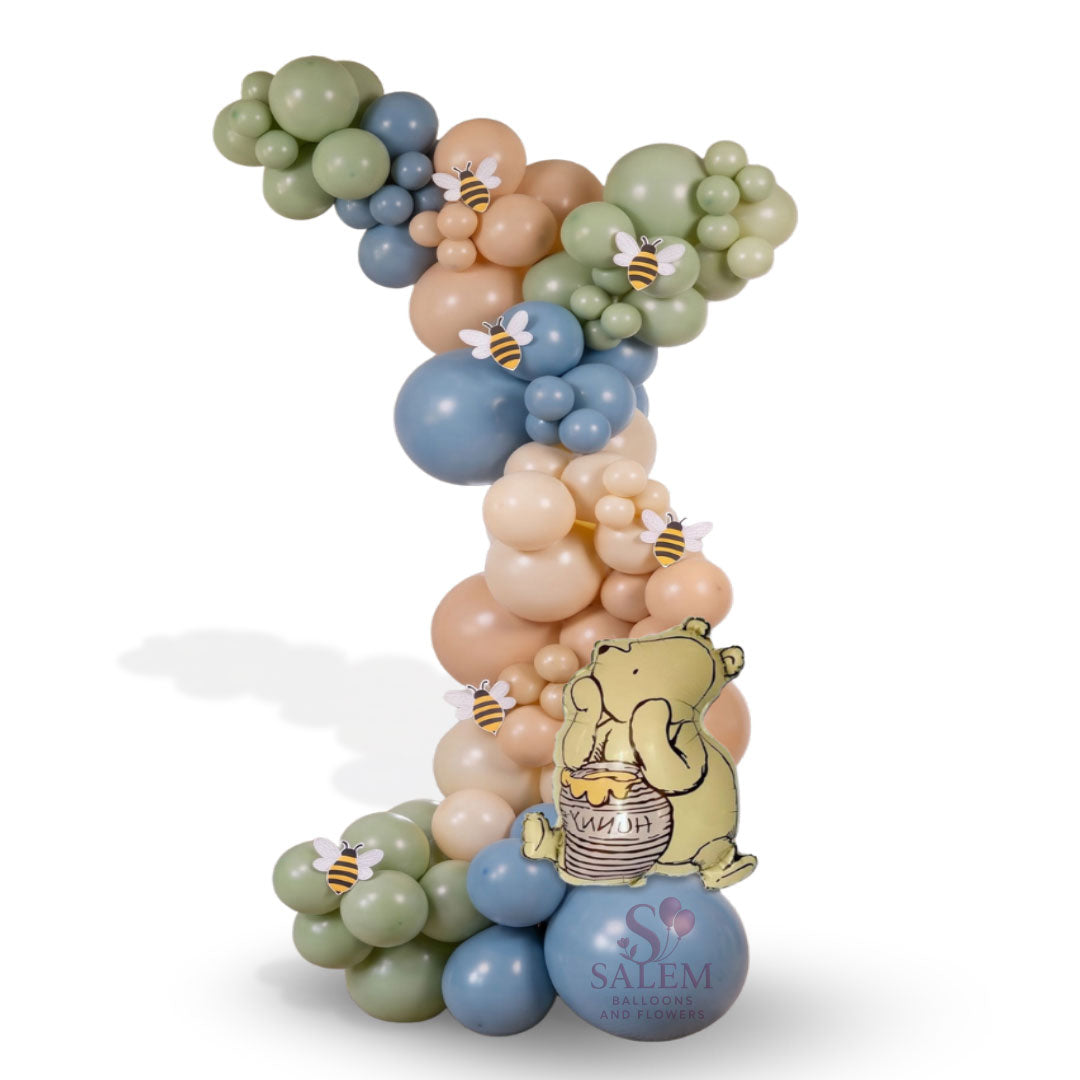 Baby shower balloon garland in pastel colors with a pooh inspired theme by Salem Balloons and flowers.