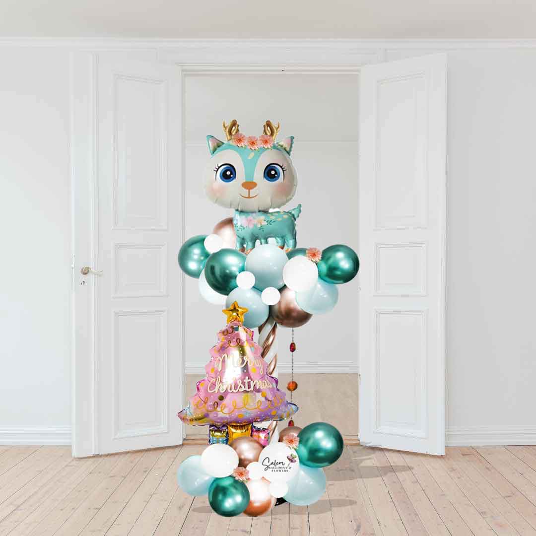 Christmas Balloon column featuring a Reindeer in pastel colors and a Christmas tree Balloon, standing in front of an open door . Christmas balloons Salem Oregon
