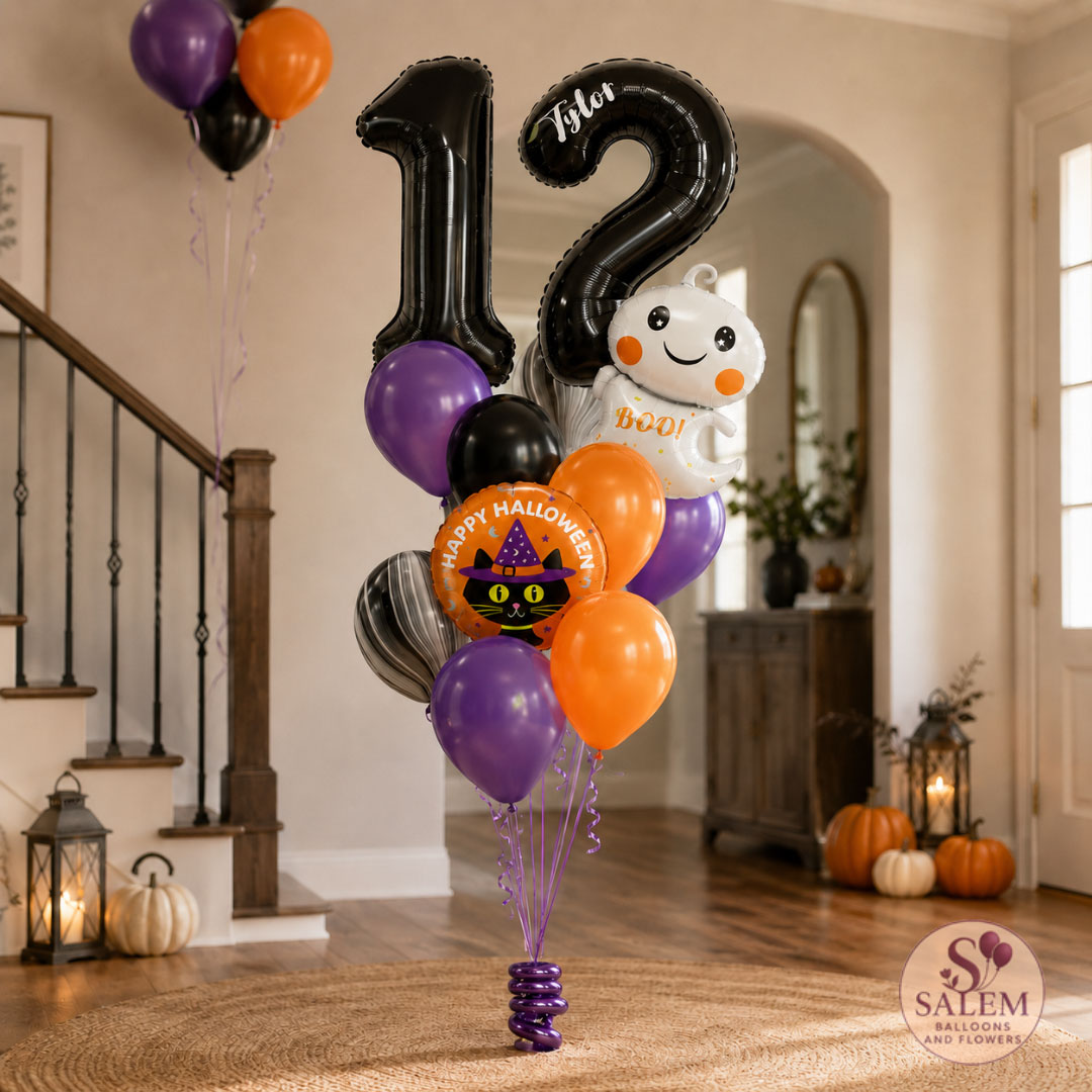 Halloween-themed balloon bouquet featuring a large black number 12 balloon, a white ghost balloon, purple and orange balloons, and a round orange 'Happy Halloween' cat balloon, displayed in a decorated home hallway with a Salem Balloons and Flowers Logo.
