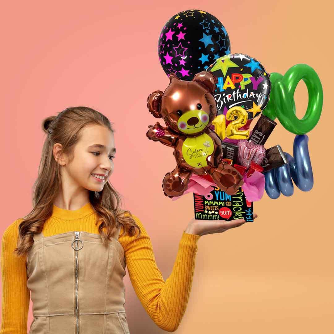 A girl holding a Balloon box gift, filled with birthday balloons, a teddy bear balloon, candy  and chocolates. Balloon delivery Salem Oregon and nearby cities.
