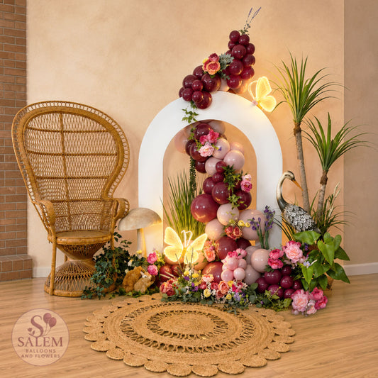 Blooming Signature Moment luxury balloon installation with floral balloon backdrop, peacock chair, illuminated butterfly lights, and elegant event décor by Salem Balloons & Flowers in Salem, Oregon.