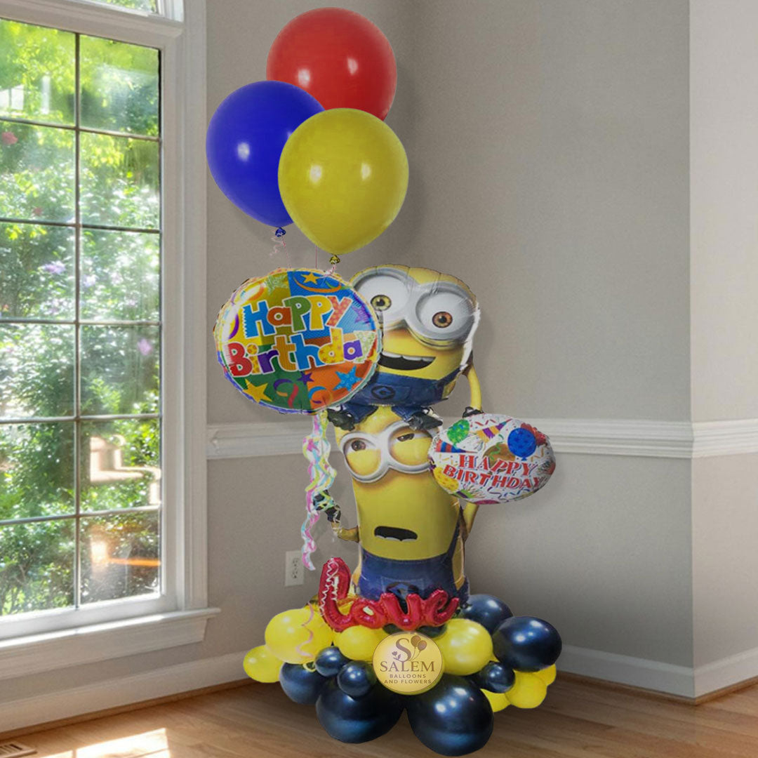 Custom Minions Happy Birthday balloon arrangement with foil Minion characters, colorful latex balloons, and a balloon base, available for delivery in Salem, Oregon from Salem Balloons and Flowers.