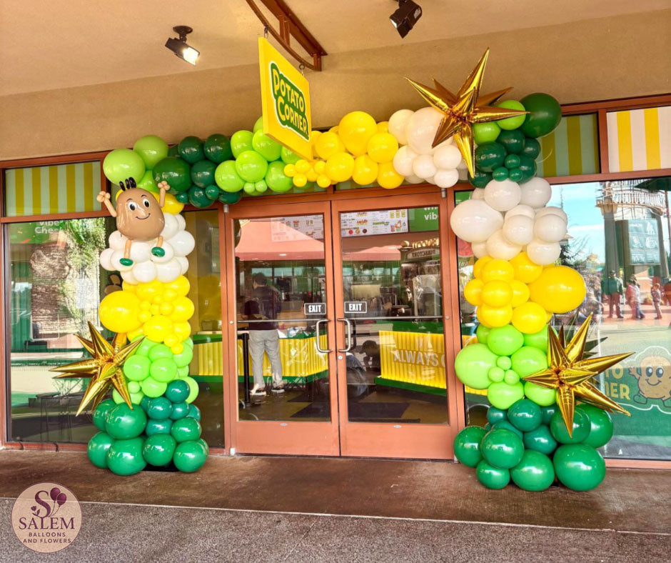 Custom green, yellow and white balloon arch with gold starbursts and handcrafted mascot-inspired sculpture for Potato Corner grand opening at Woodburn Premium Outlets in Oregon.