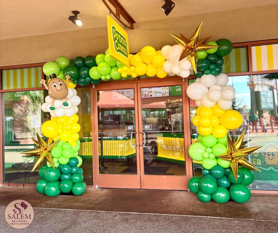 Custom green, yellow and white balloon arch with gold starbursts and handcrafted mascot-inspired sculpture for Potato Corner grand opening at Woodburn Premium Outlets in Oregon.