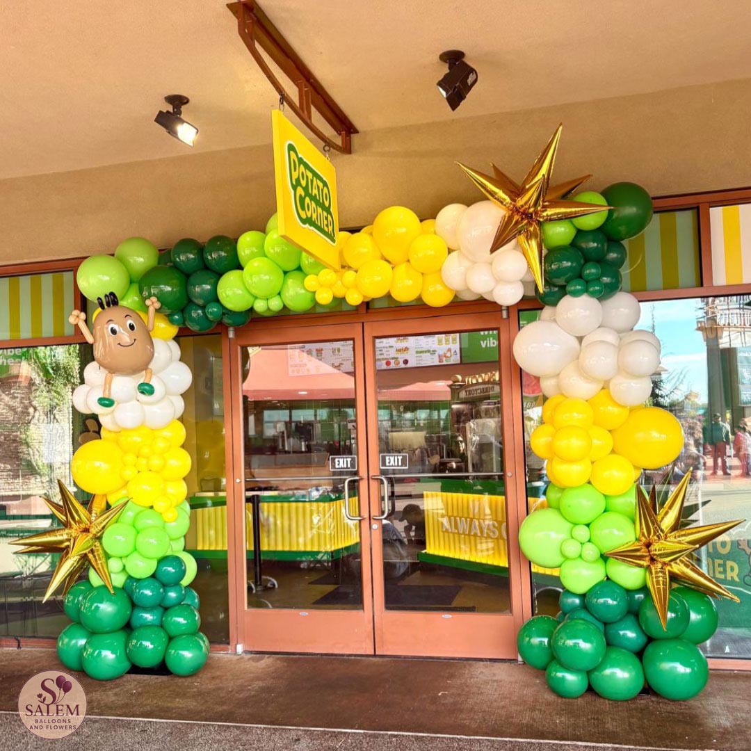 Custom green, yellow and white balloon arch with gold starbursts and handcrafted mascot-inspired sculpture for Potato Corner grand opening at Woodburn Premium Outlets in Oregon.