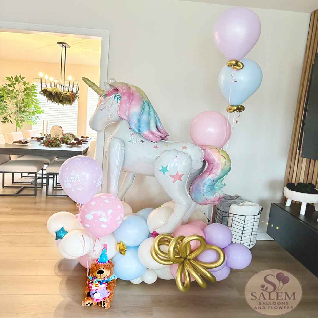 Unicorn balloon sculpture with colorful balloons in a room setting, featuring 'Salem Balloons & Flowers' branding.