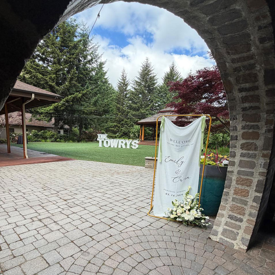 Wedding reception entrance featuring custom welcome signage and illuminated “THE TOWRYS” marquee letters at Paradise Springs in Monroe, Oregon. Wedding focal decor by Salem Balloons and Flowers.

