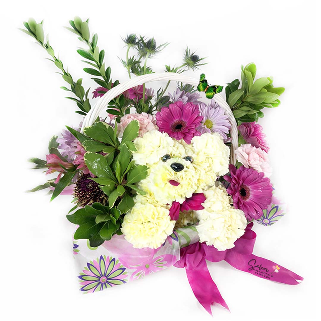 Basket flower arrangement. Featuring flower puppy poking out through the fresh beautiful flowers in a handcrafted basket. Awakening smiles and tender wiggles is easy with this playful Puppy Basket arrangement. A thoughtful gift for your favorite animal-lover! Free delivery in Salem Oregon and nearby areas.
